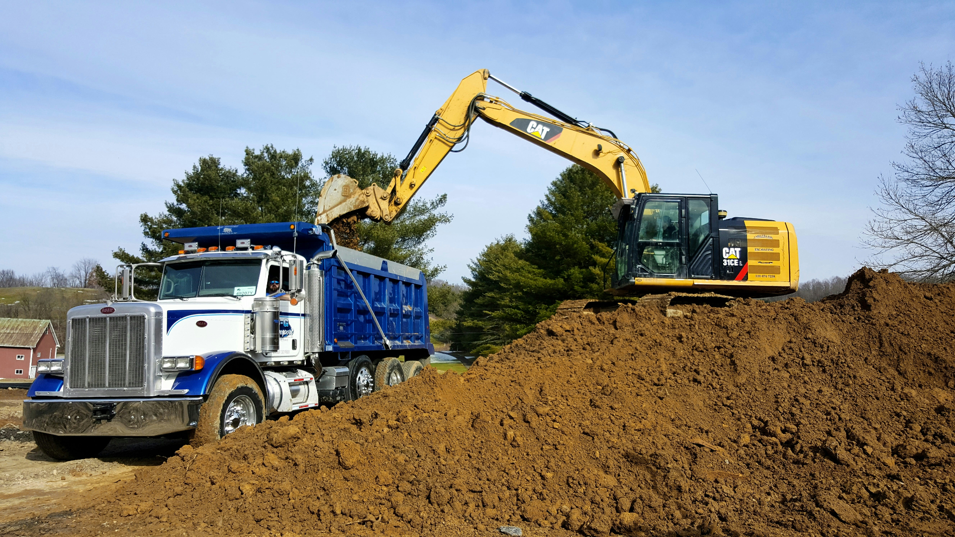 Excavator loading a dump truck with material for delivery