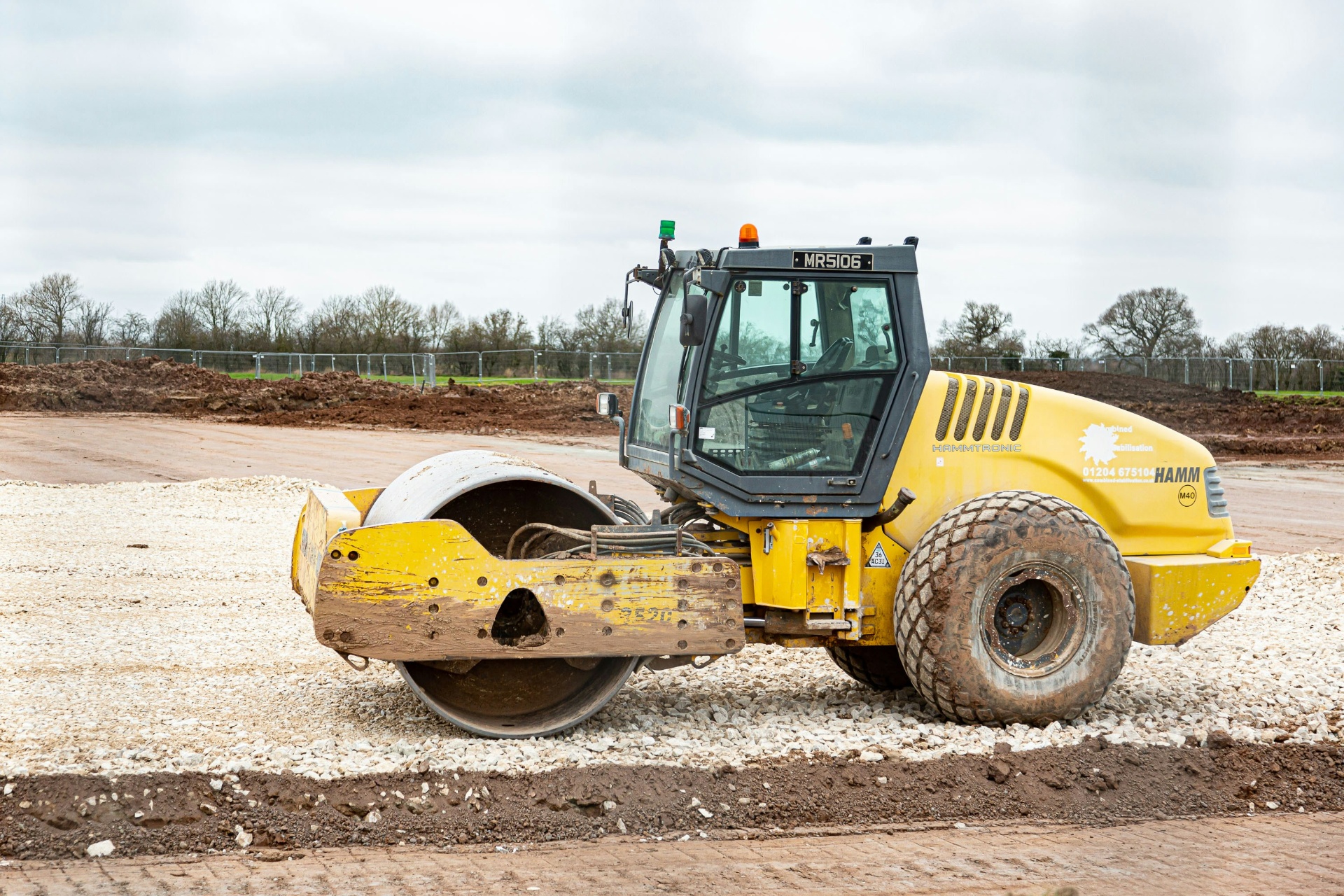 Vibratory smooth-drum roller compacting a fresh gravel base