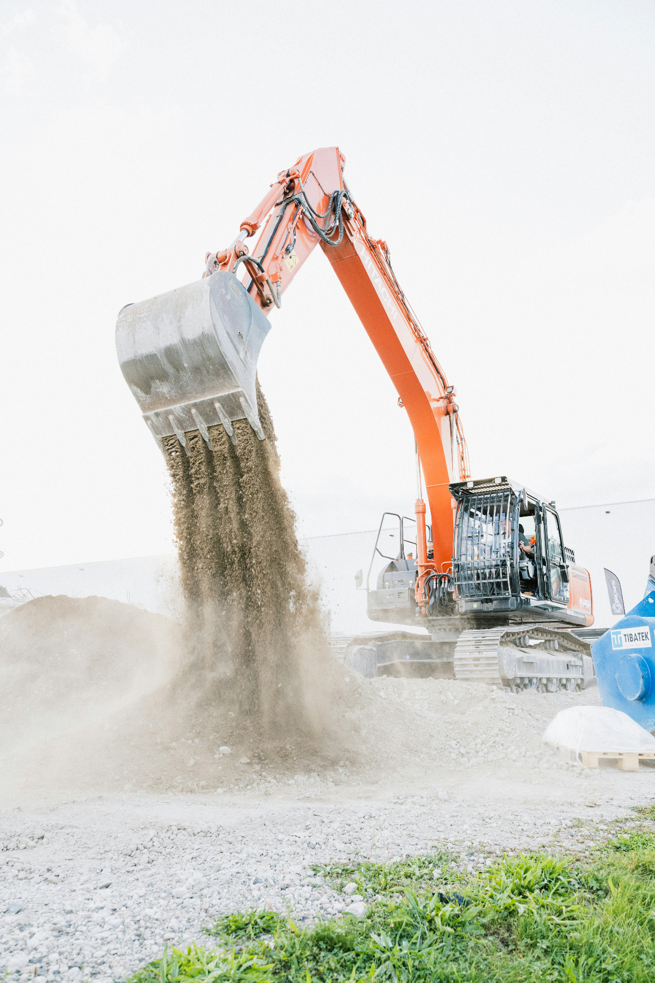 Excavator dumping material during an industrial yard maintenance visit